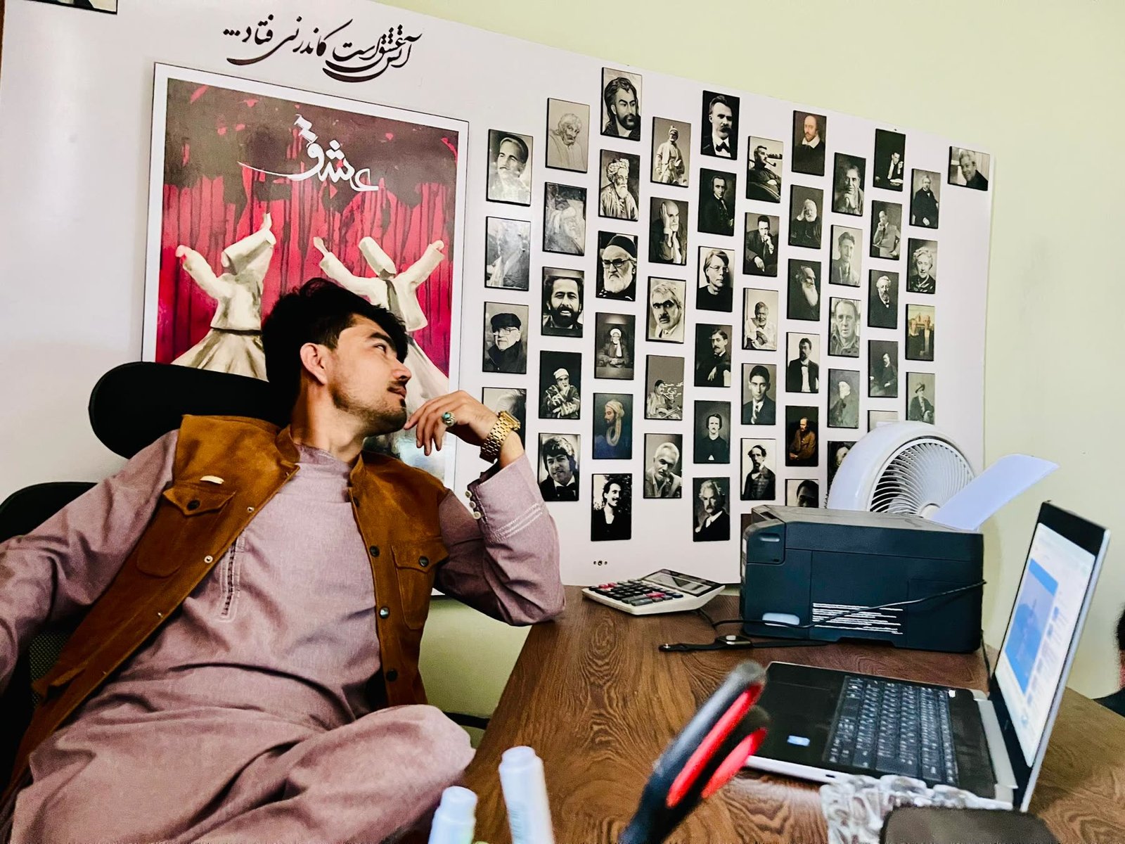 Zamanuddin Zafar at the studio, framed by a wall of Persian poets
